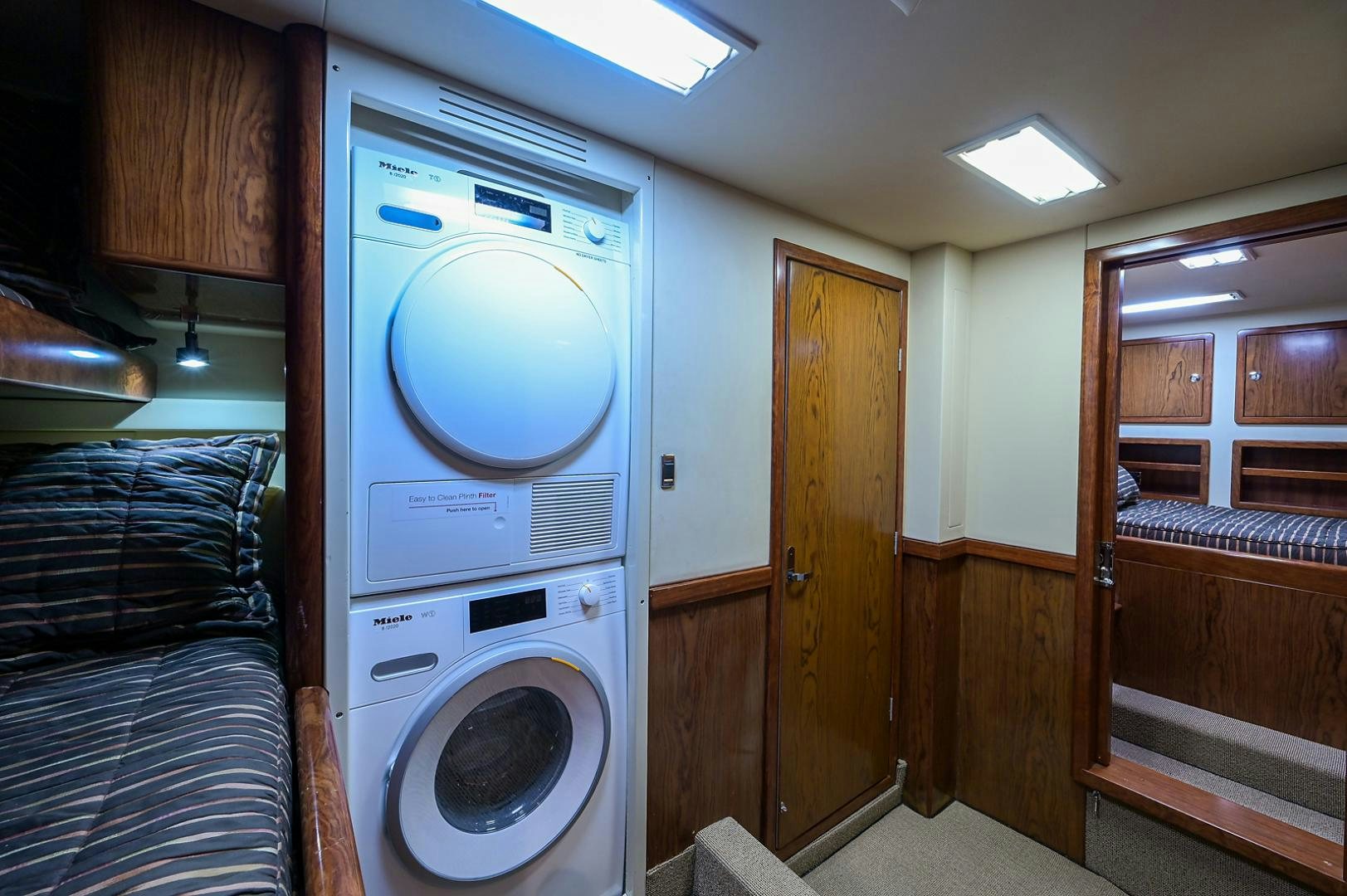 a room with a washing machine and a bed aboard BLACK SHADOW Yacht for Sale