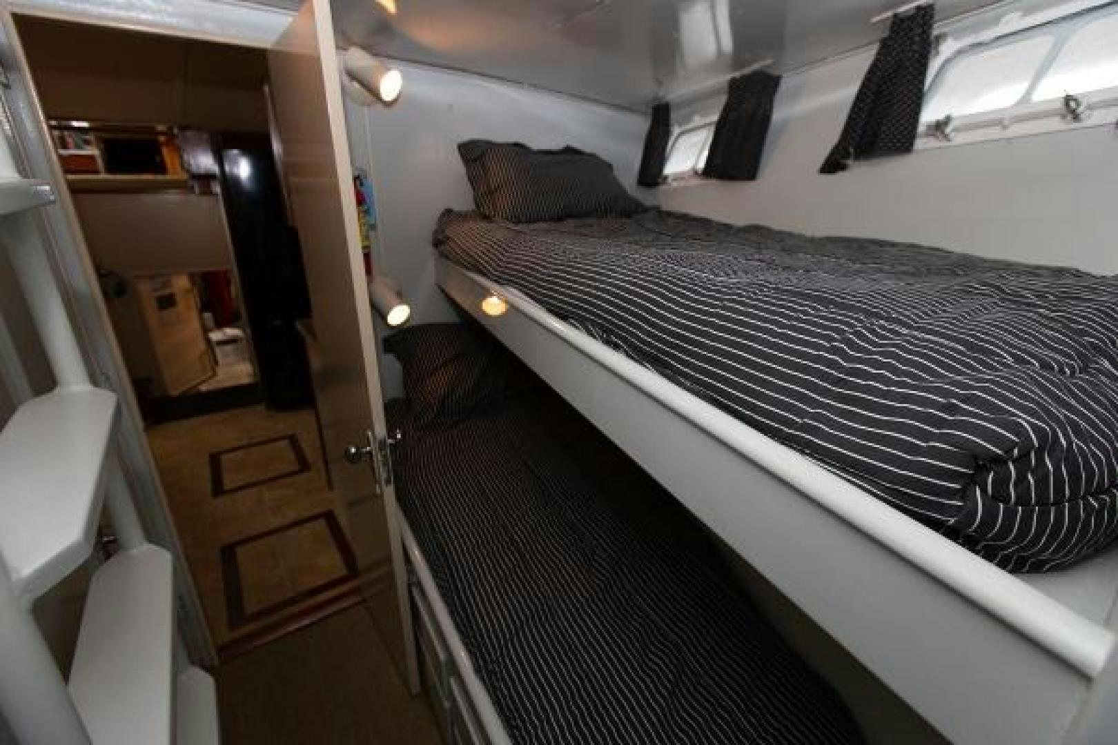 a bed with a black and white bed spread aboard No Name Yacht for Sale
