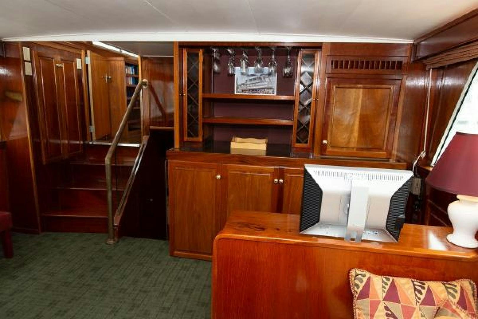 a room with a piano and a bookcase aboard No Name Yacht for Sale