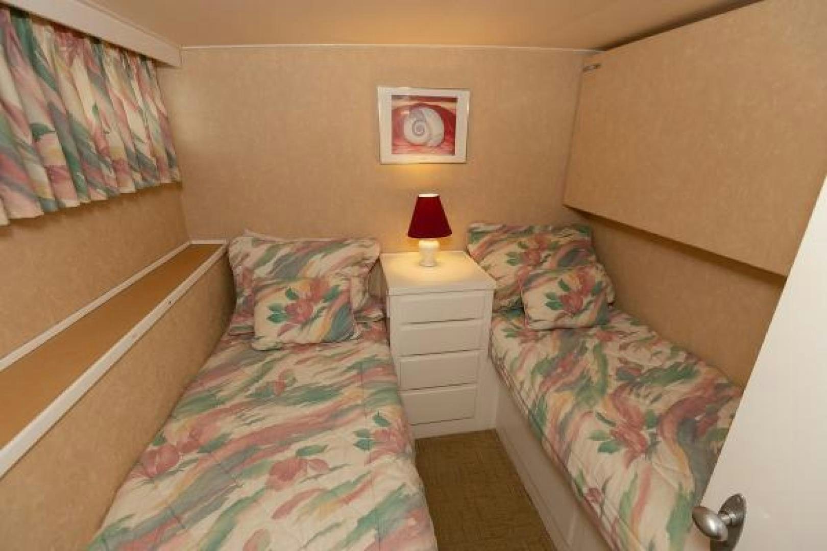 a bedroom with a bed and a lamp aboard No Name Yacht for Sale