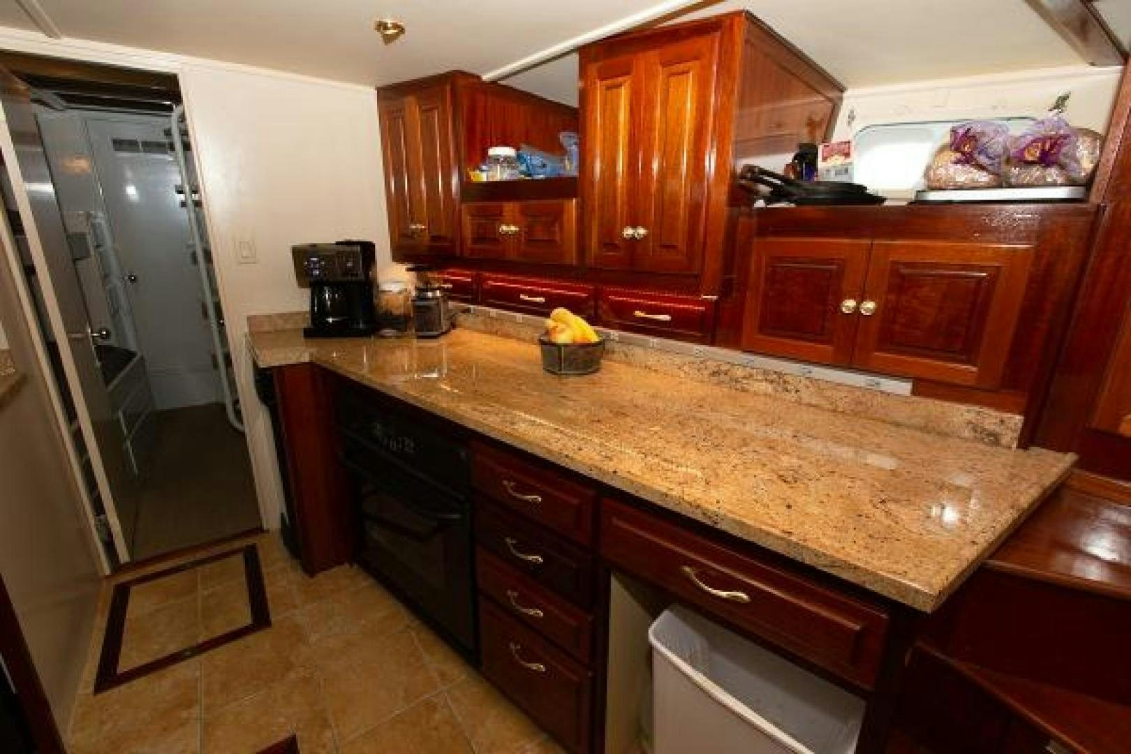 a kitchen with wooden cabinets aboard No Name Yacht for Sale