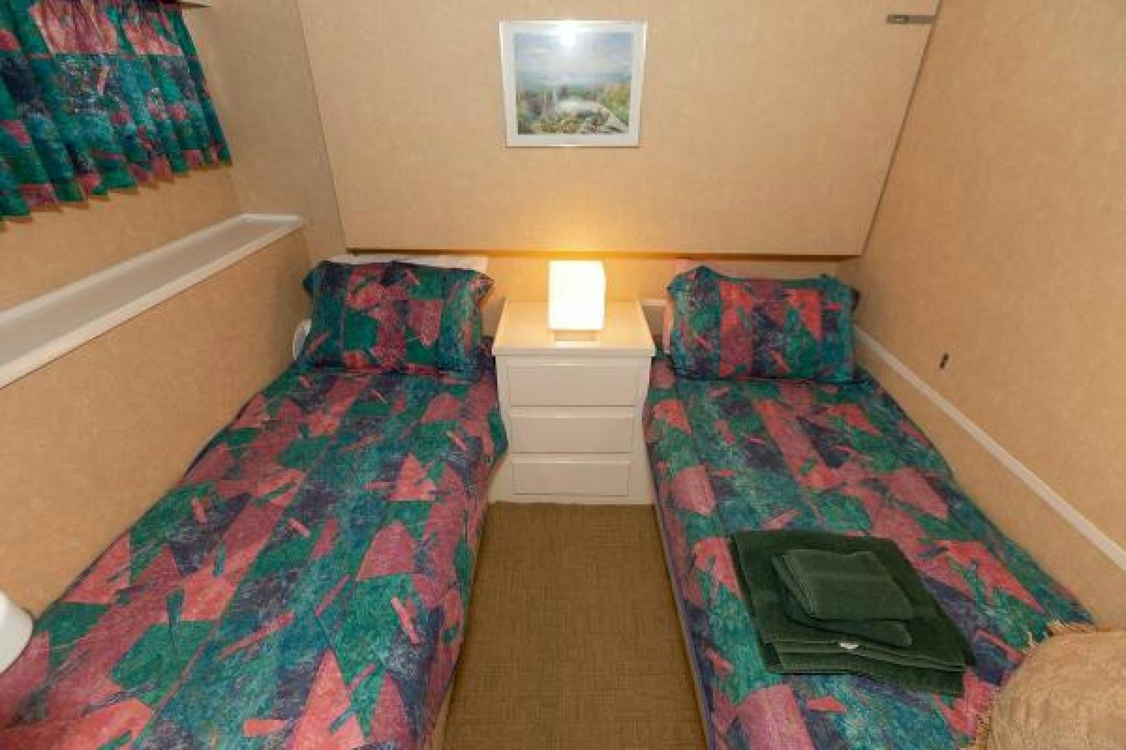 a bedroom with a bed and a dresser aboard No Name Yacht for Sale