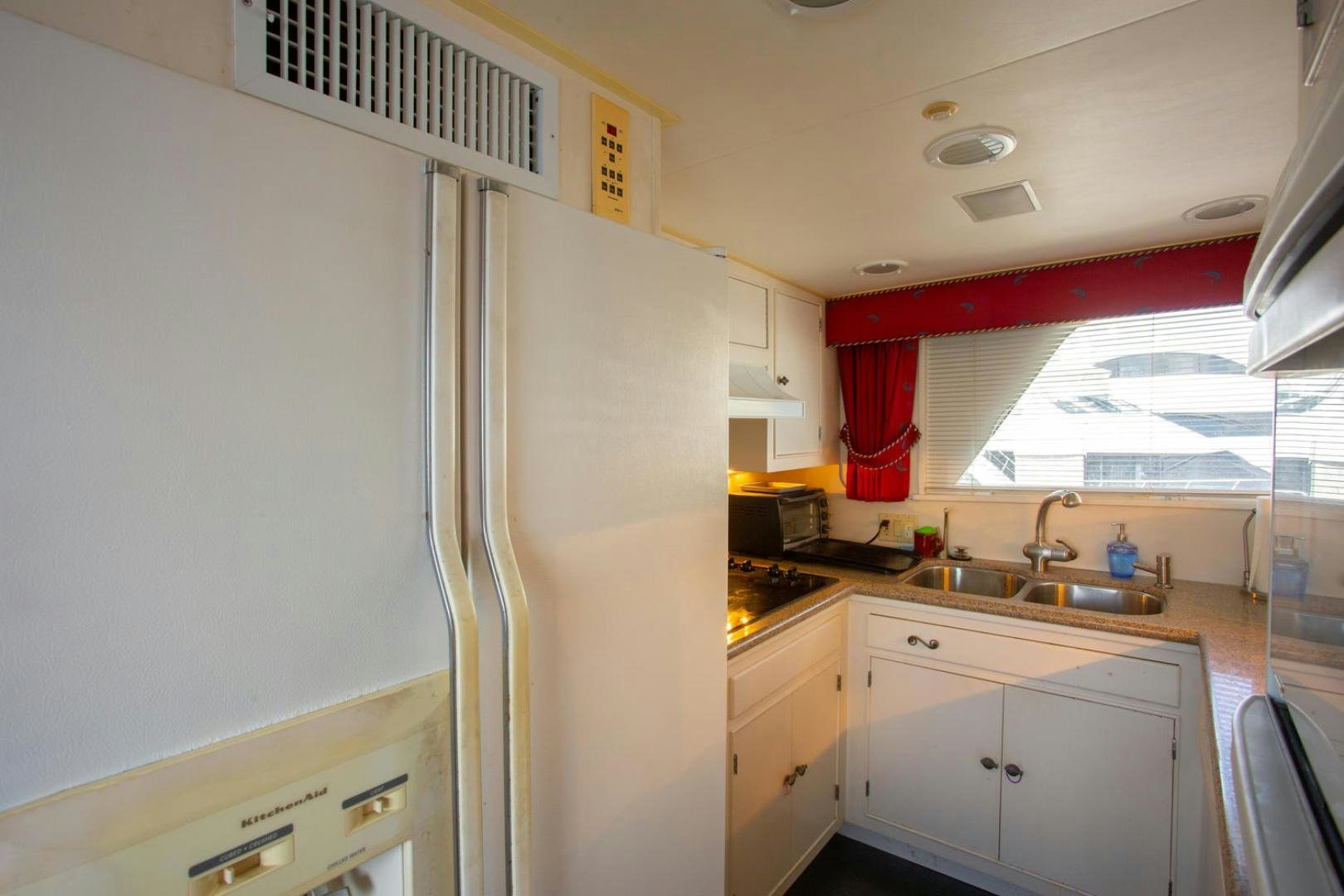 a kitchen with a refrigerator and sink aboard HIGH MILEAGE Yacht for Sale