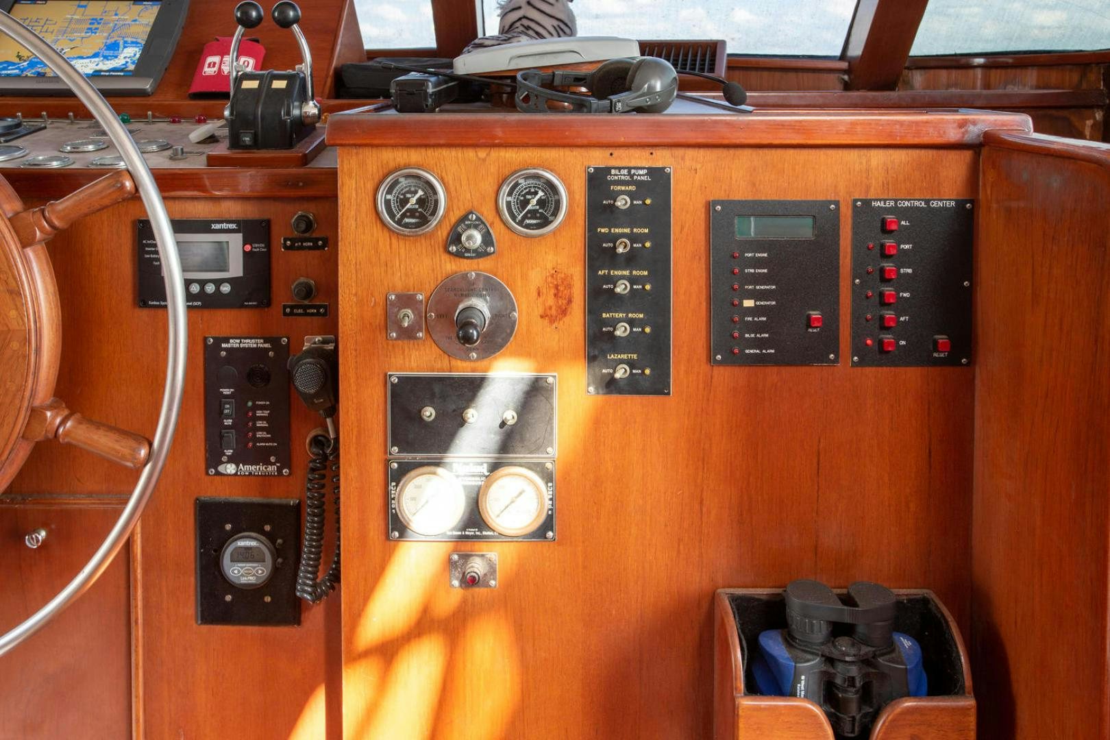 a wooden cabinet with various electronics aboard HIGH MILEAGE Yacht for Sale