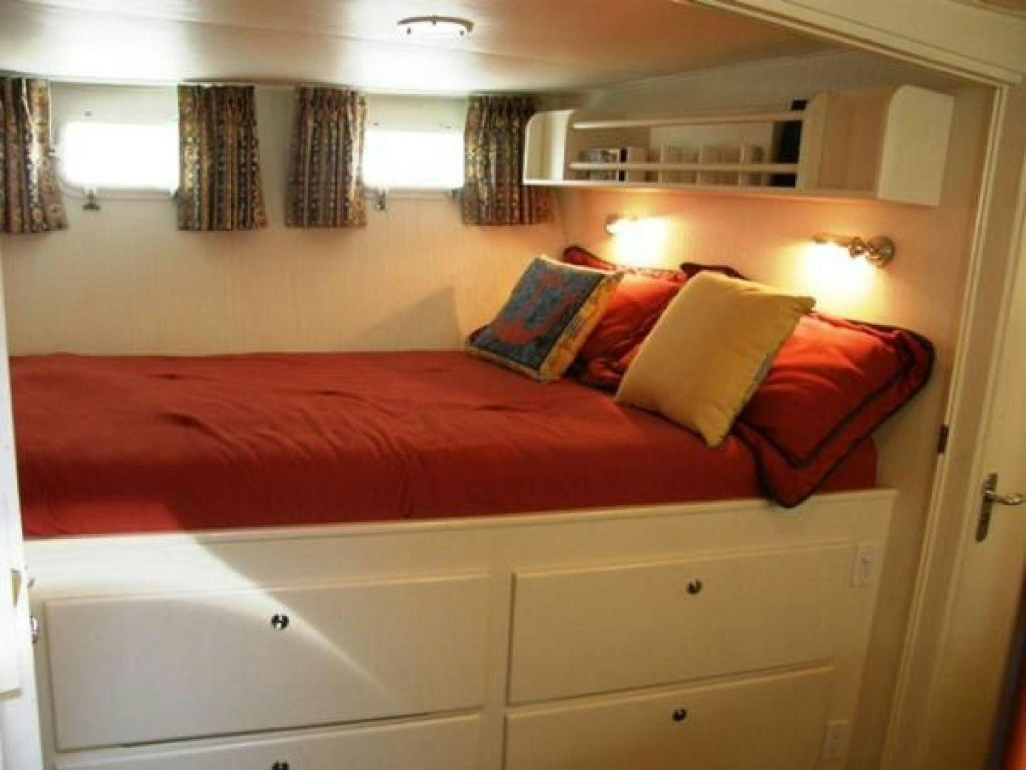 a bed with red pillows aboard HIGH MILEAGE Yacht for Sale