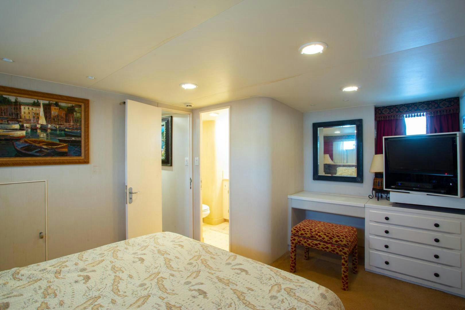 a bedroom with a tv and a bed aboard HIGH MILEAGE Yacht for Sale