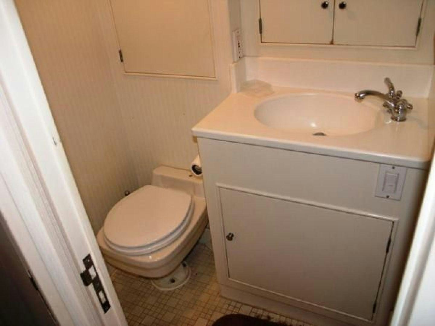 a bathroom with a sink and toilet aboard HIGH MILEAGE Yacht for Sale