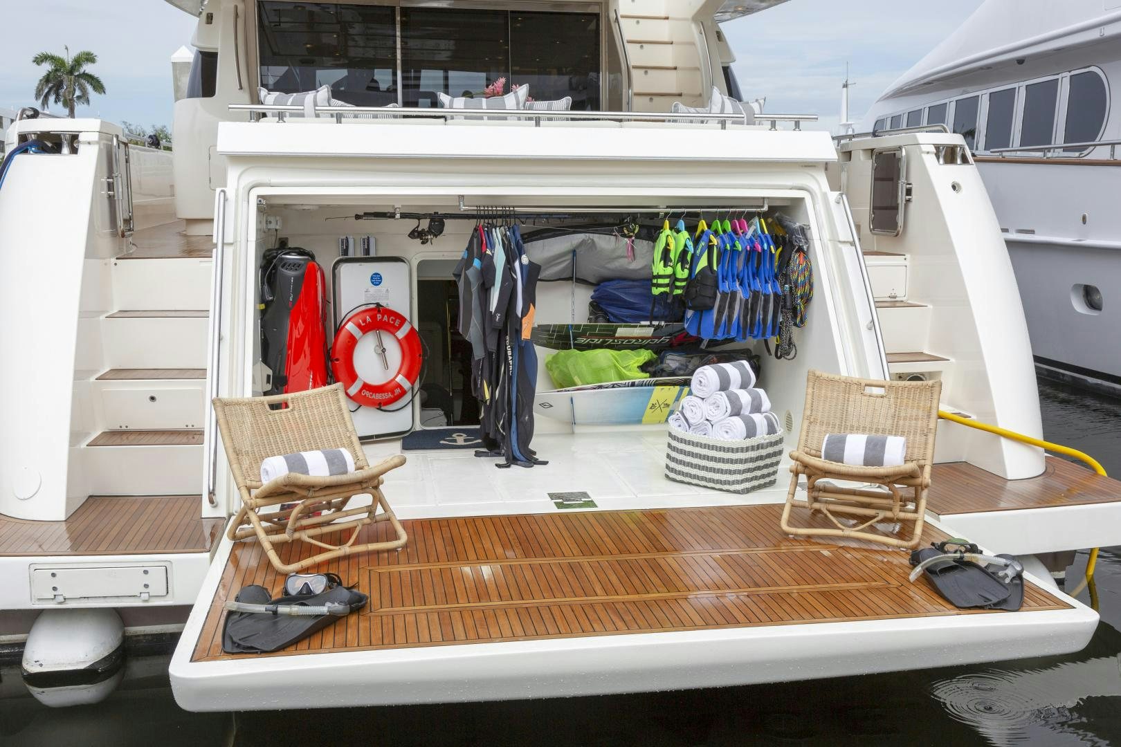 a boat with a rack of clothes and a chair on the deck aboard LA PACE Yacht for Sale