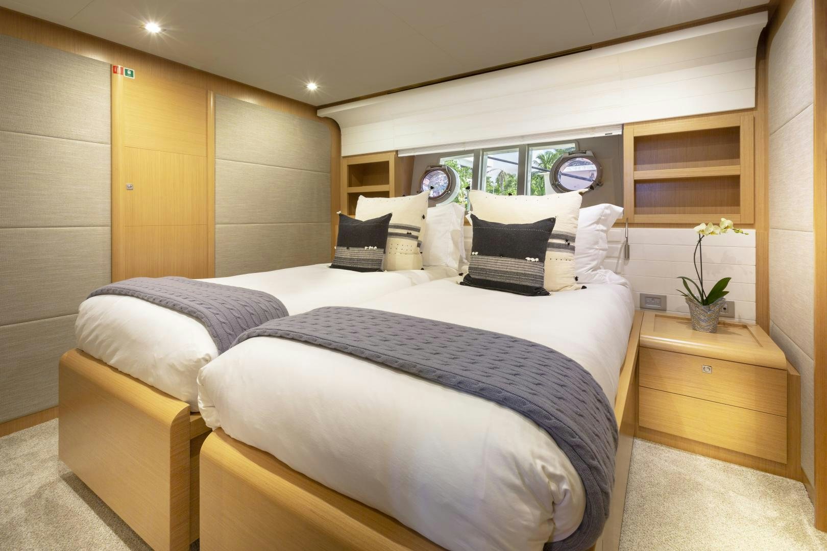 a bed with a white comforter and pillows in a room with wood cabinets and a wood cabinet aboard LA PACE Yacht for Sale