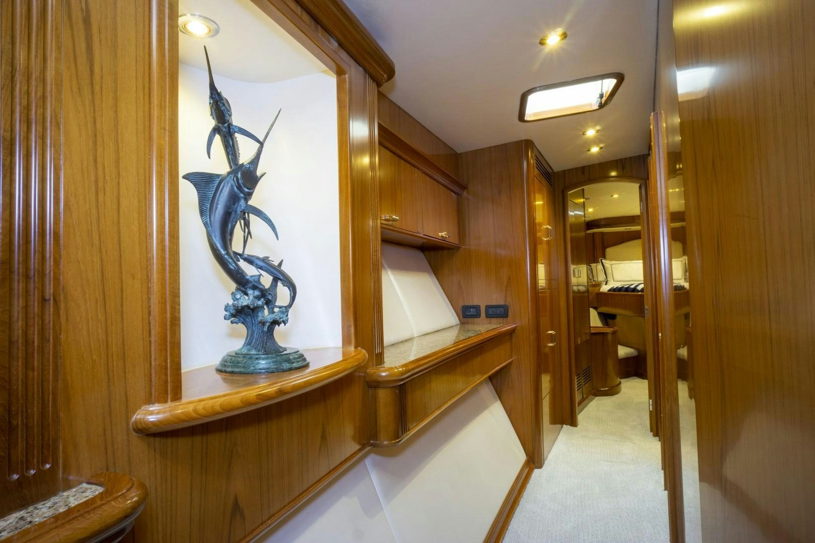 a room with wood cabinets and a statue aboard REEL DEAL Yacht for Sale