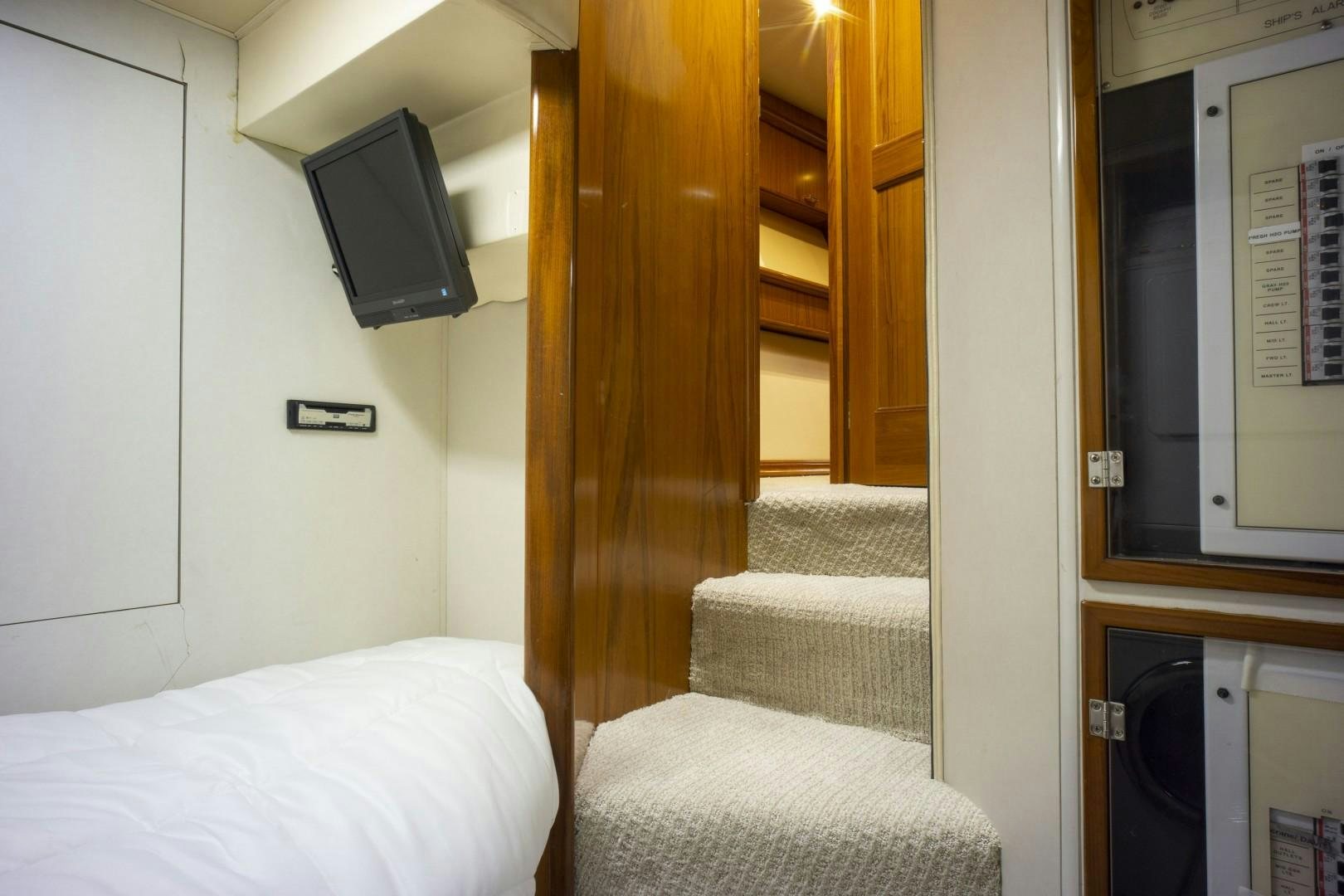 a room with a bed and a television aboard REEL DEAL Yacht for Sale