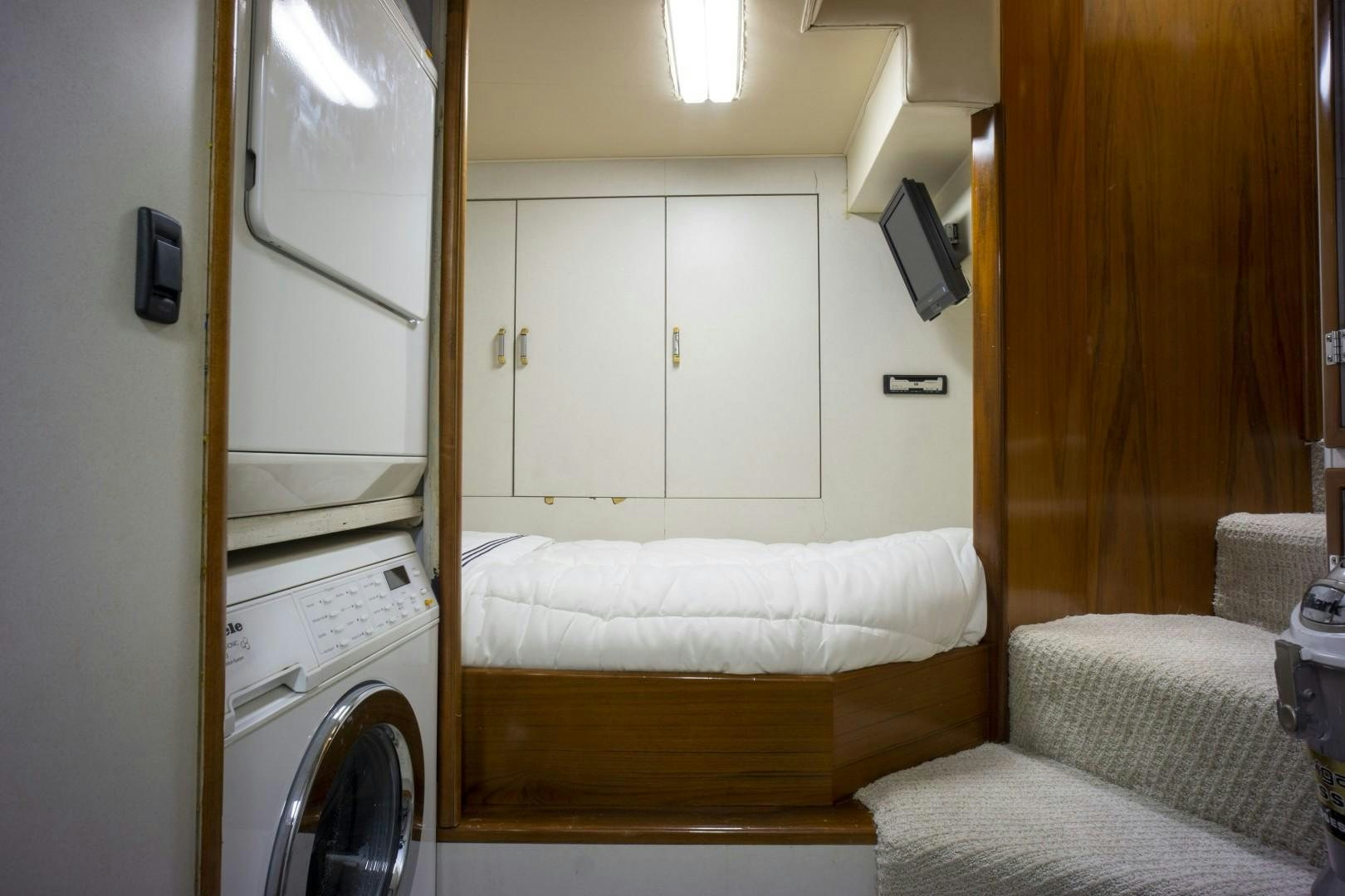 a room with a bed and washer and dryer aboard REEL DEAL Yacht for Sale