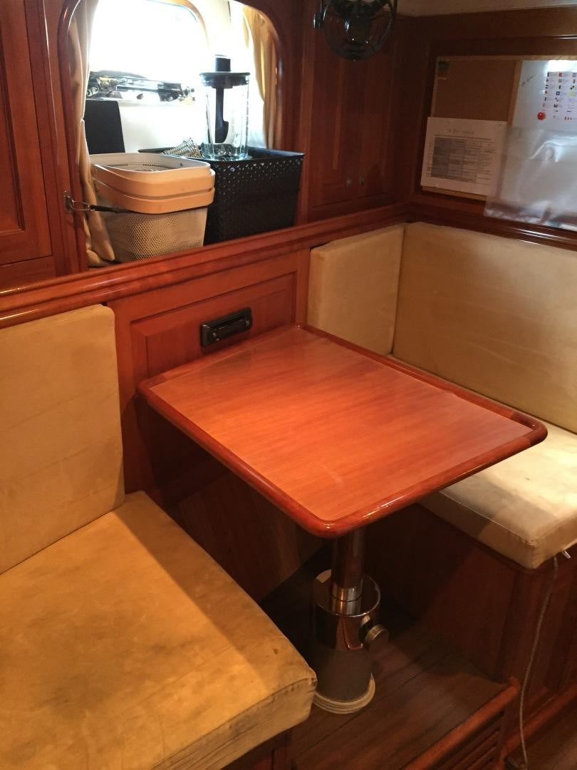 a wooden table in a room aboard TIGA BELAS Yacht for Sale