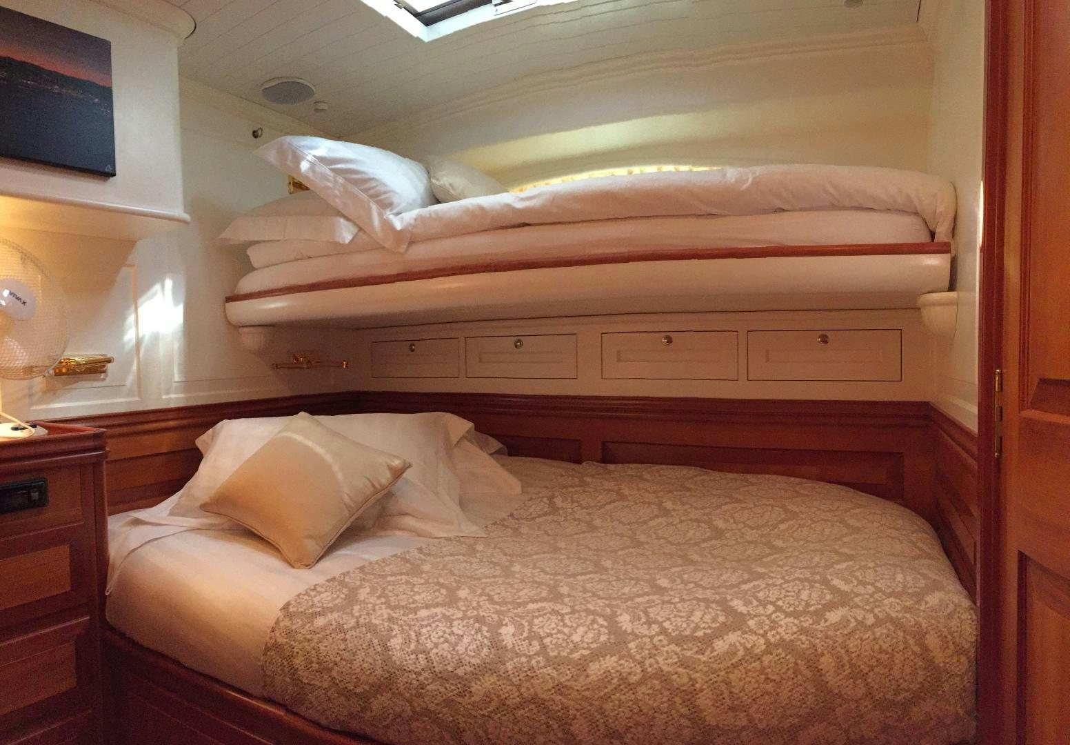 a bed with a wooden headboard aboard TIGA BELAS Yacht for Sale