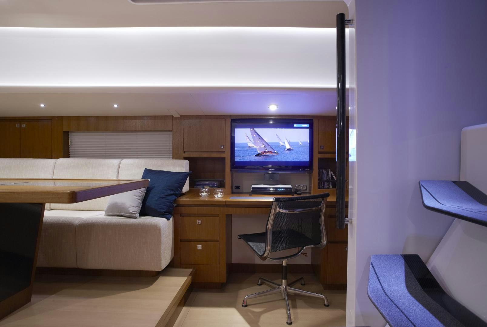 a living room with a couch and a television aboard SINGULARITY Yacht for Sale