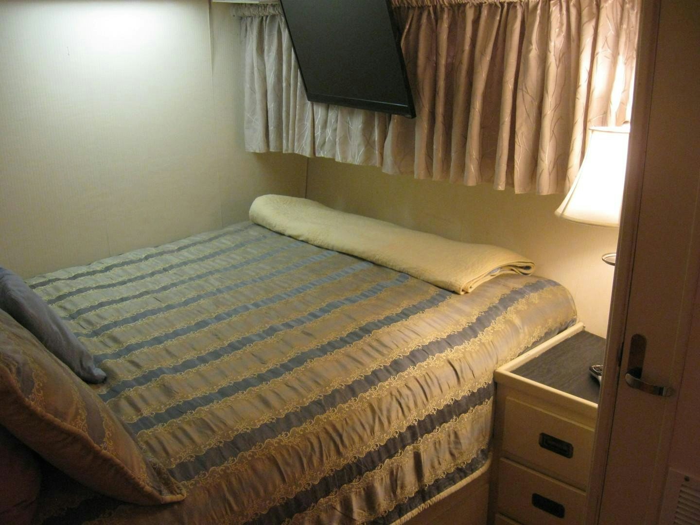 a bed with a blue and white comforter aboard OCEAN ROMANCE Yacht for Sale
