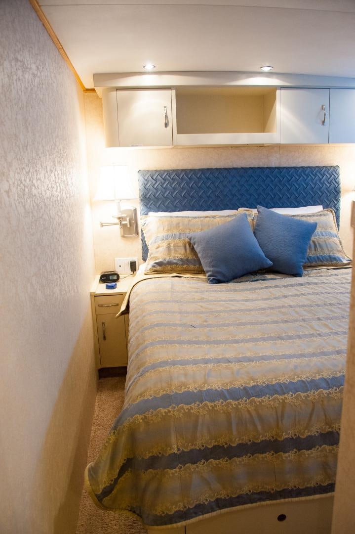 a bedroom with a bed and cabinets aboard OCEAN ROMANCE Yacht for Sale