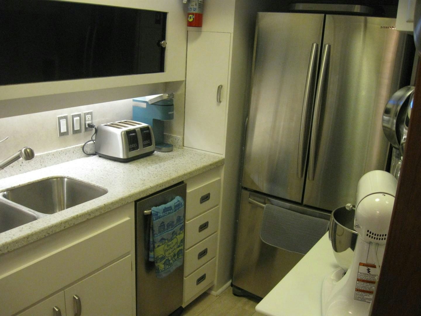 a kitchen with a stainless steel refrigerator aboard OCEAN ROMANCE Yacht for Sale
