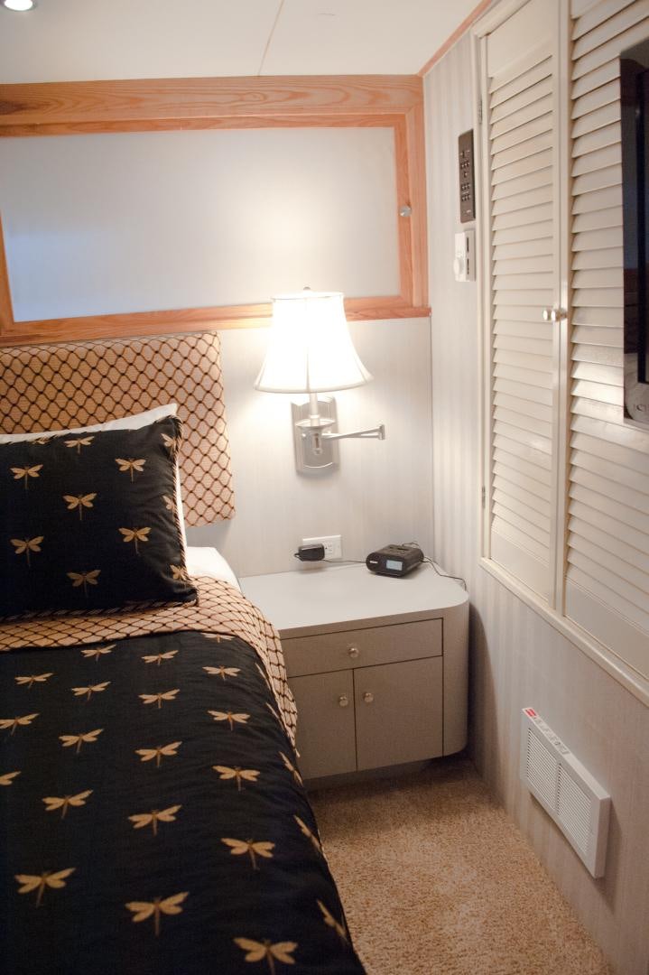 a bedroom with a bed and a lamp aboard OCEAN ROMANCE Yacht for Sale