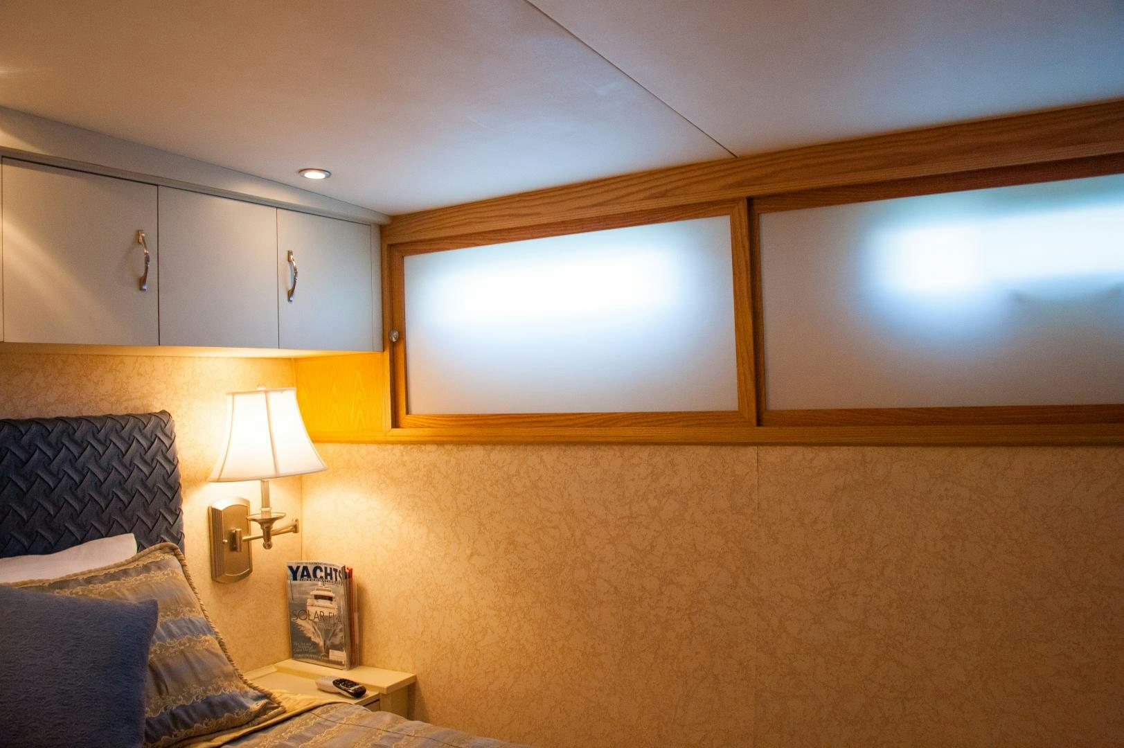 a bedroom with a bed and a lamp aboard OCEAN ROMANCE Yacht for Sale