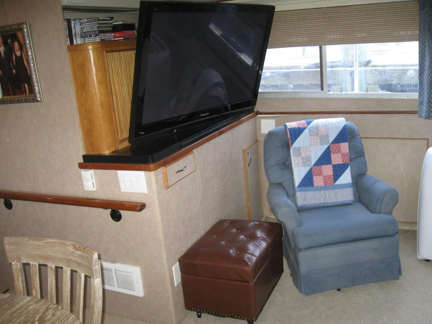 a living room with a television and a chair aboard OCEAN ROMANCE Yacht for Sale