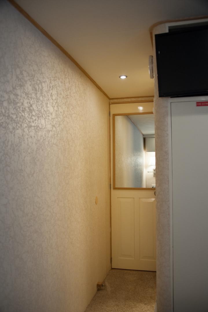 a room with a tv and a door aboard OCEAN ROMANCE Yacht for Sale