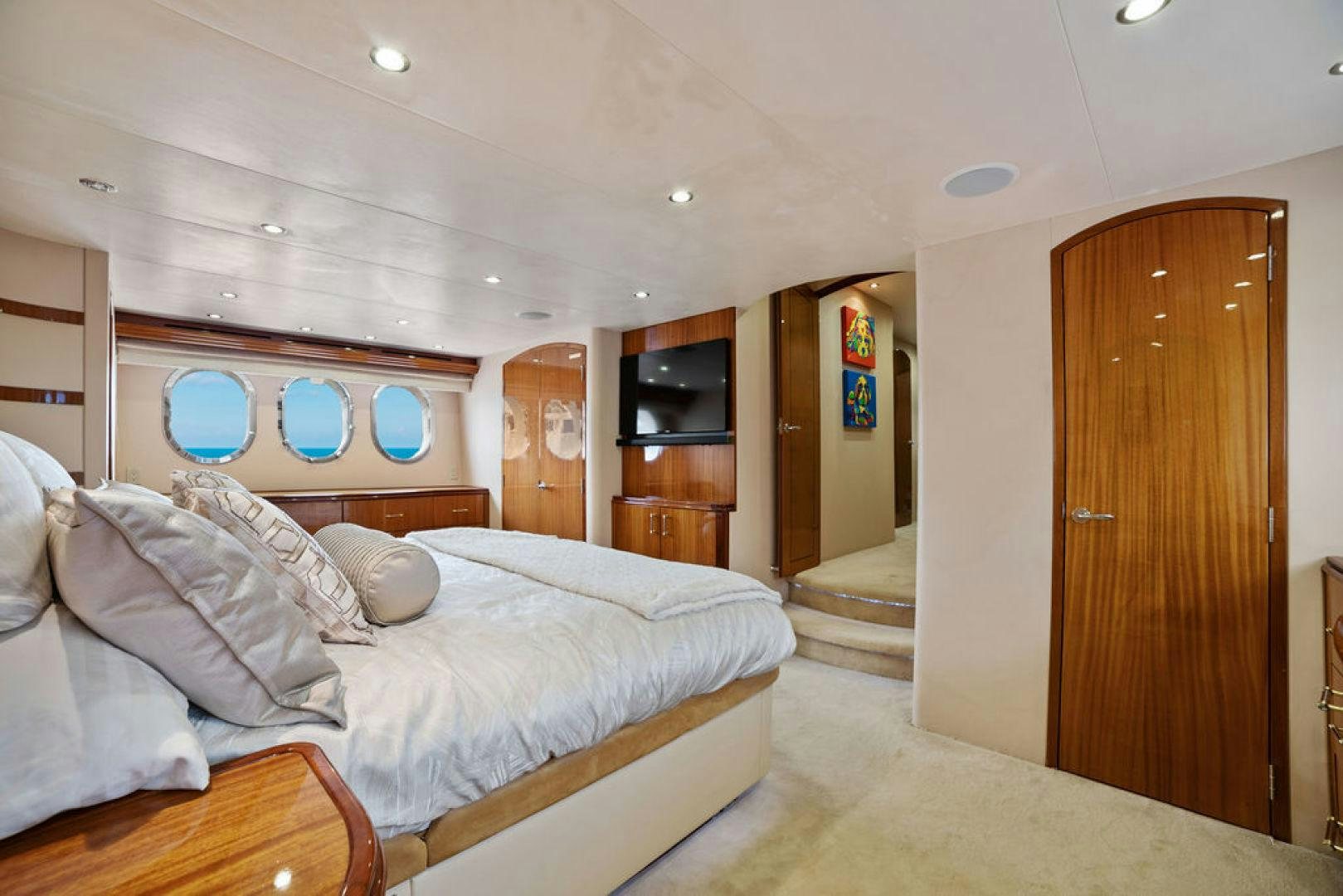 a bedroom with a bed and a wood door aboard LA MER Yacht for Sale