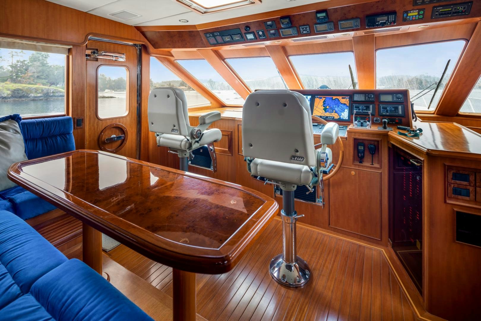 a wooden table with chairs and a bench aboard CAPTIVA Yacht for Sale