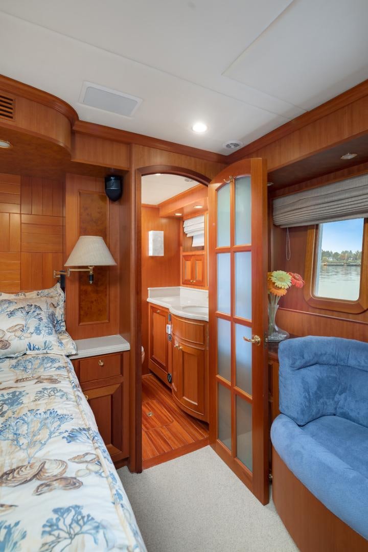 a bedroom with a bed and a desk aboard CAPTIVA Yacht for Sale