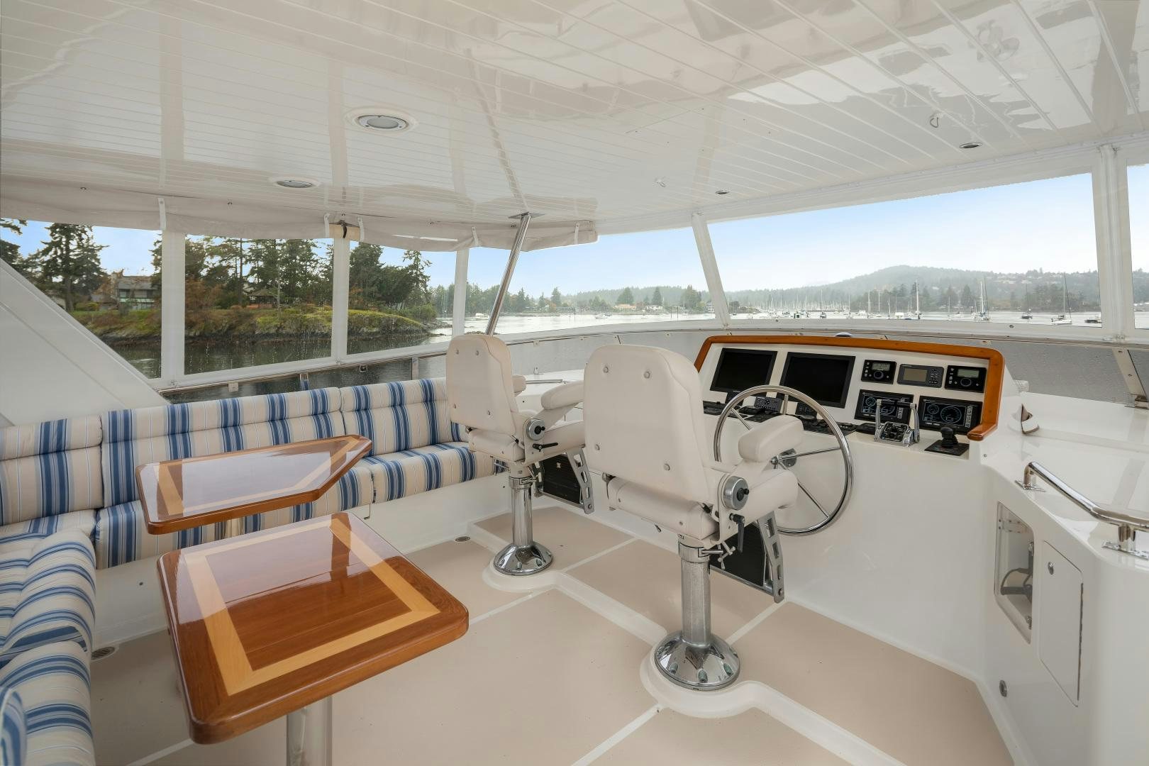 a white lounge chair in a room with a table and chairs aboard CAPTIVA Yacht for Sale