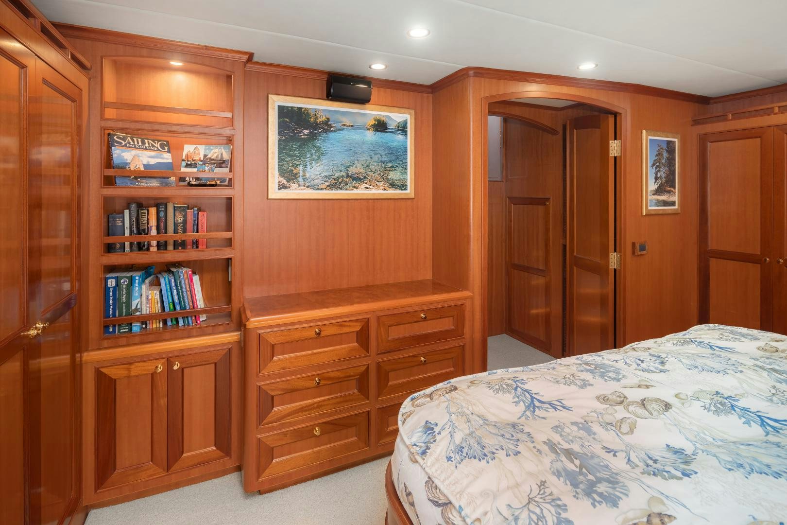 a bedroom with a bookcase and a bed aboard CAPTIVA Yacht for Sale
