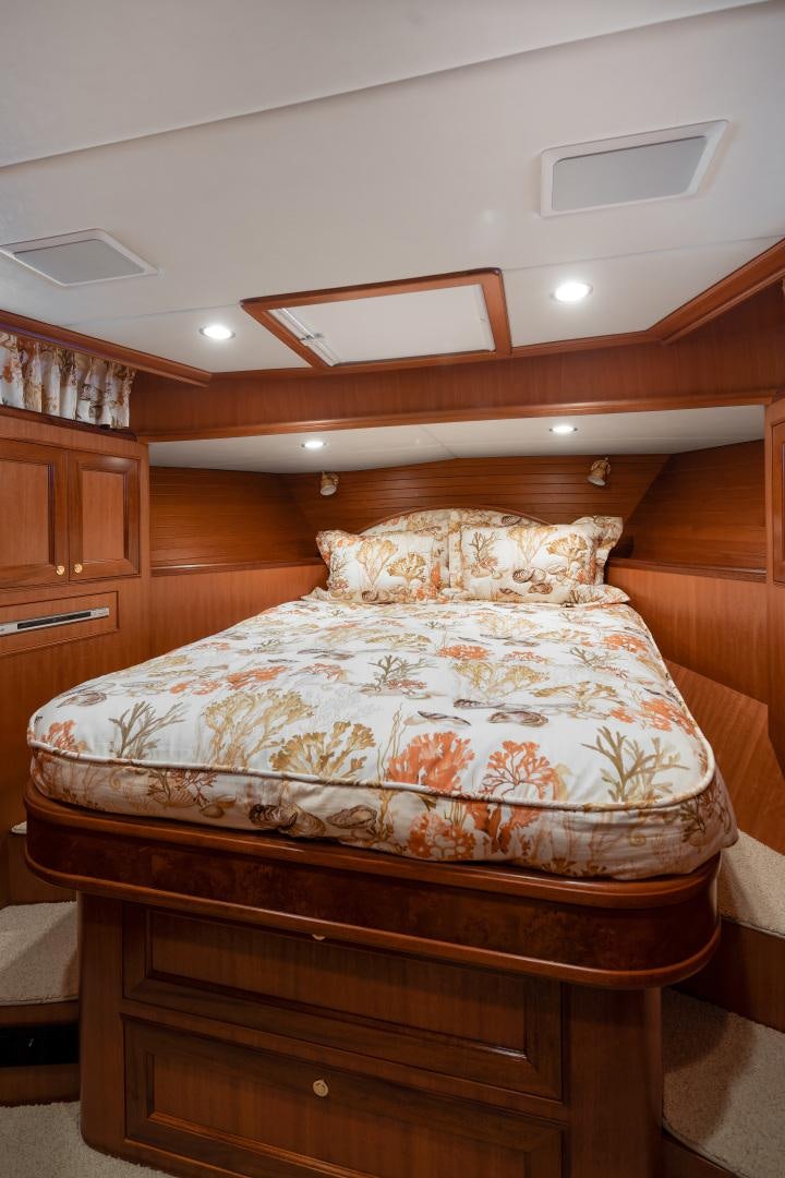 a bed with a wooden headboard aboard CAPTIVA Yacht for Sale
