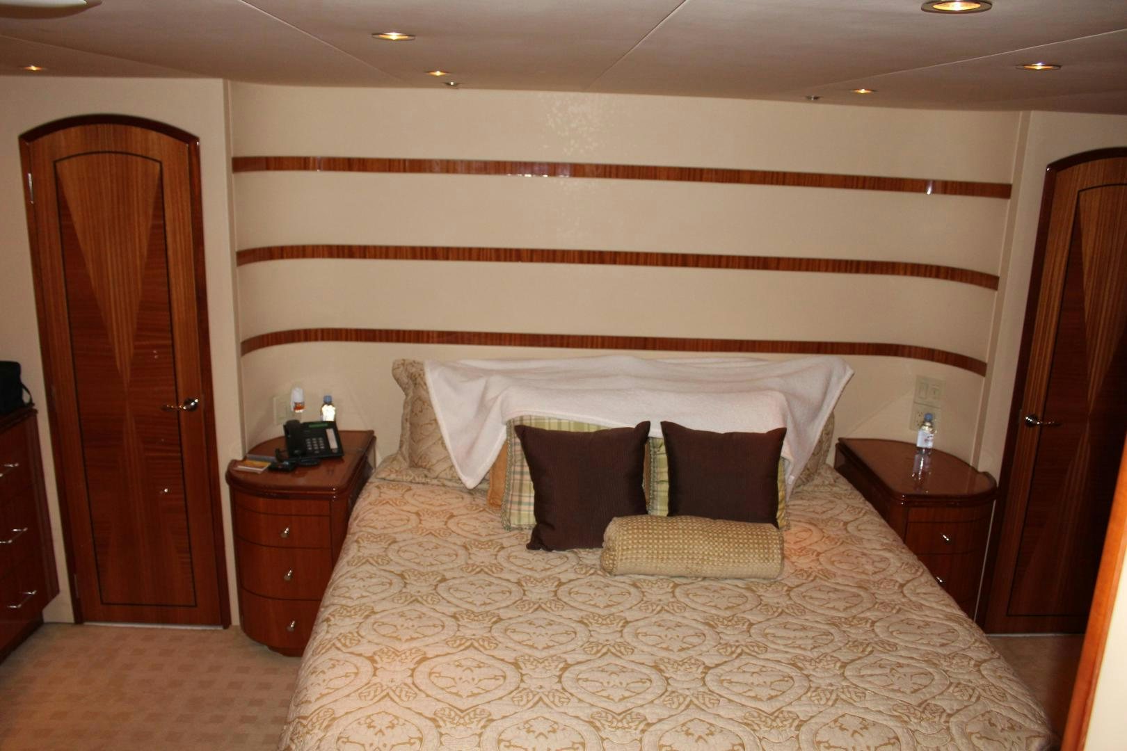 a bed with white and orange sheets aboard No Name Yacht for Sale