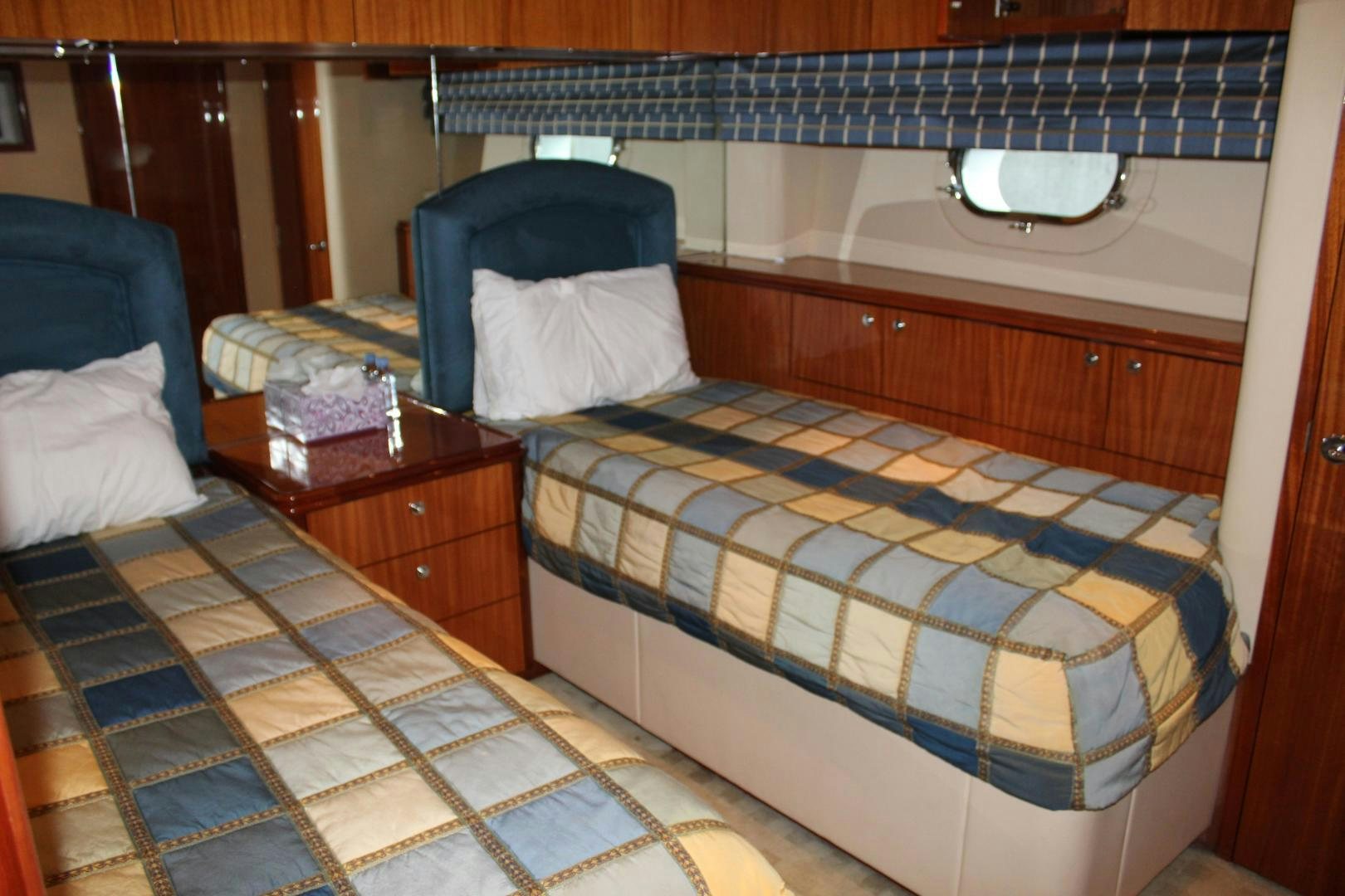 a bed with a blue and white checkered blanket aboard No Name Yacht for Sale