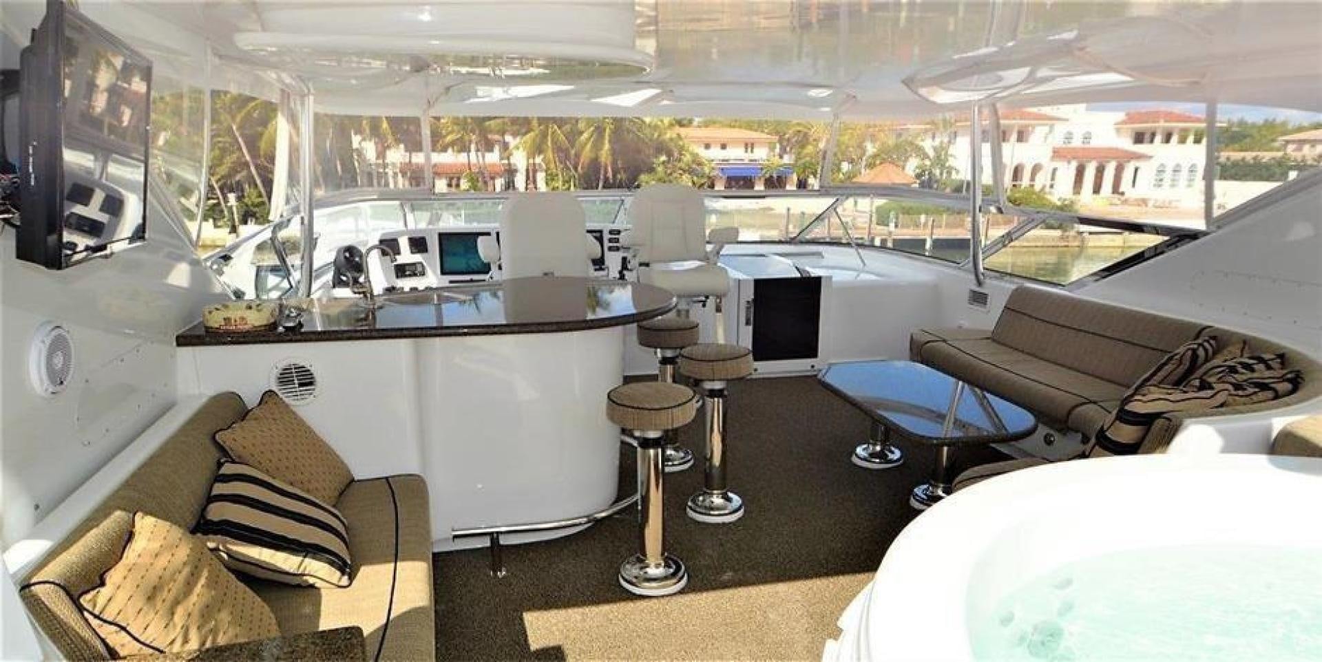 a room with a couch and a table with chairs and a television aboard VICTORY Yacht for Sale