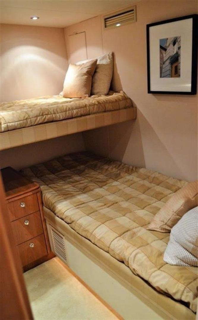 a bed with a striped comforter aboard VICTORY Yacht for Sale