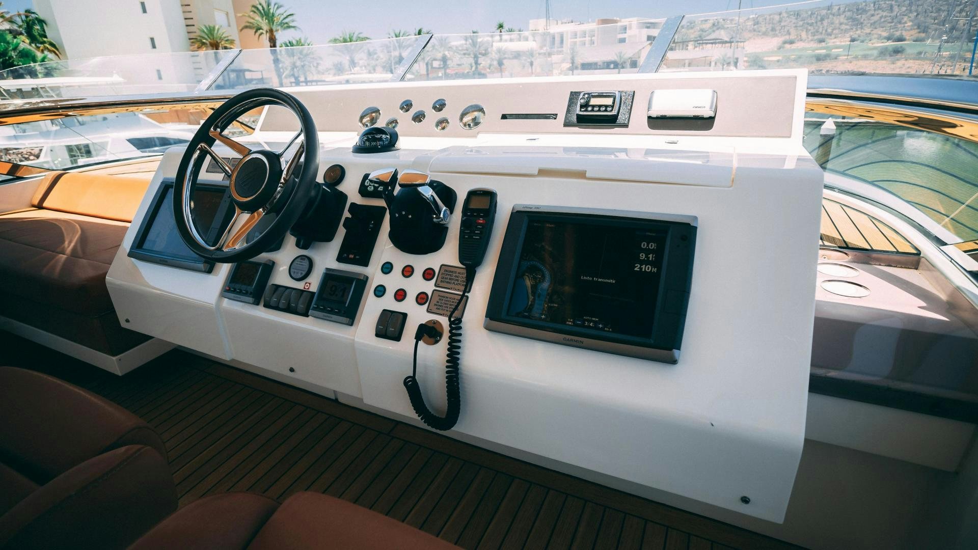 a white console with a steering wheel and a screen on the side aboard OCHO UNO Yacht for Sale