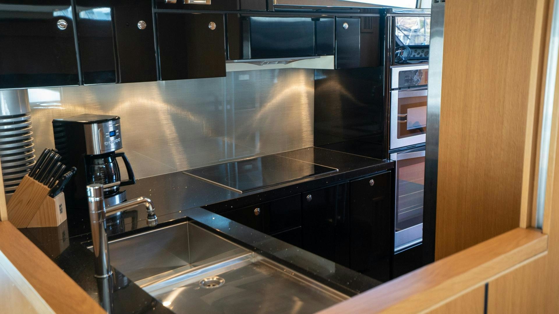 a kitchen with black cabinets aboard OCHO UNO Yacht for Sale