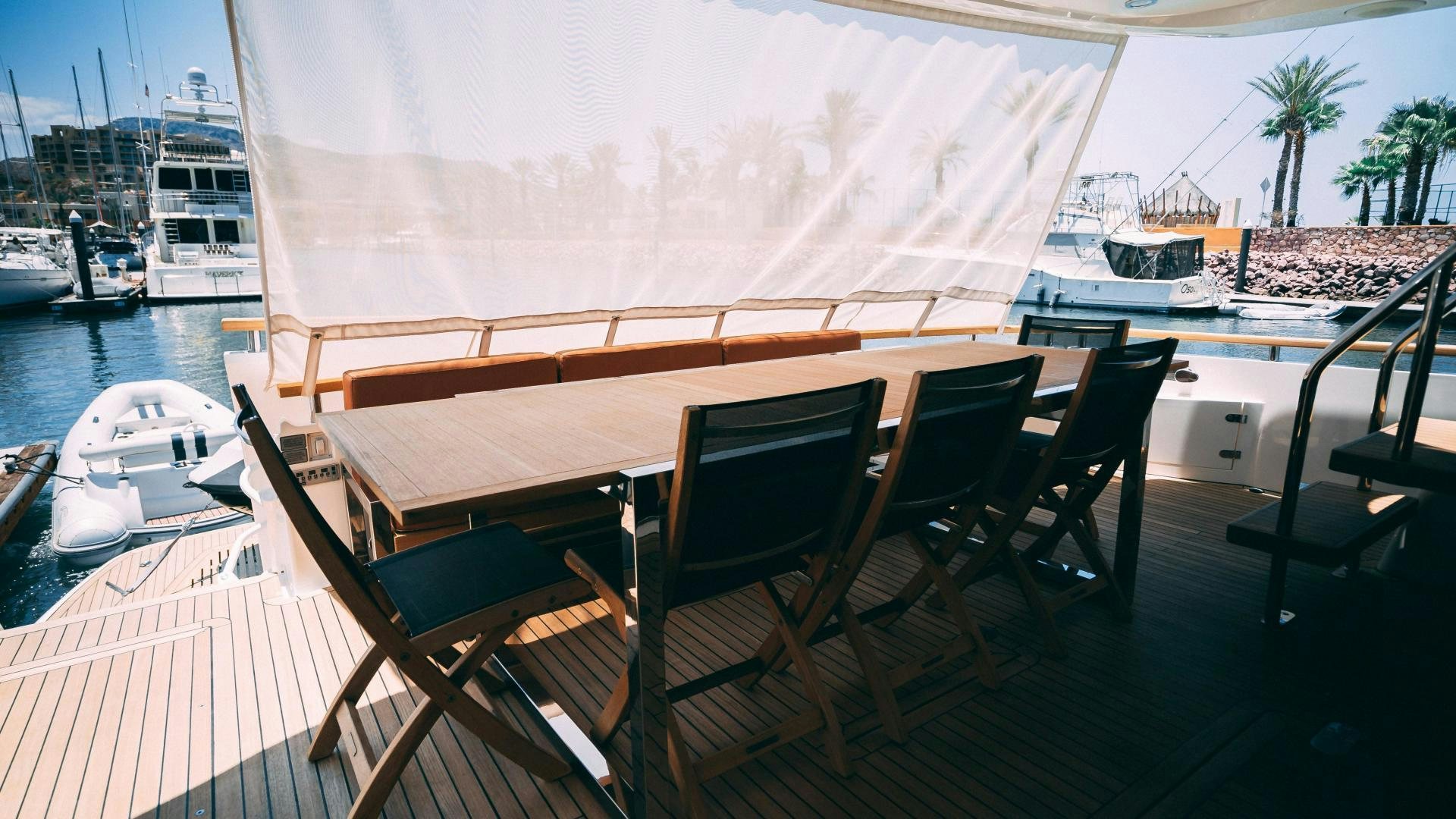 a table and chairs on a deck aboard OCHO UNO Yacht for Sale