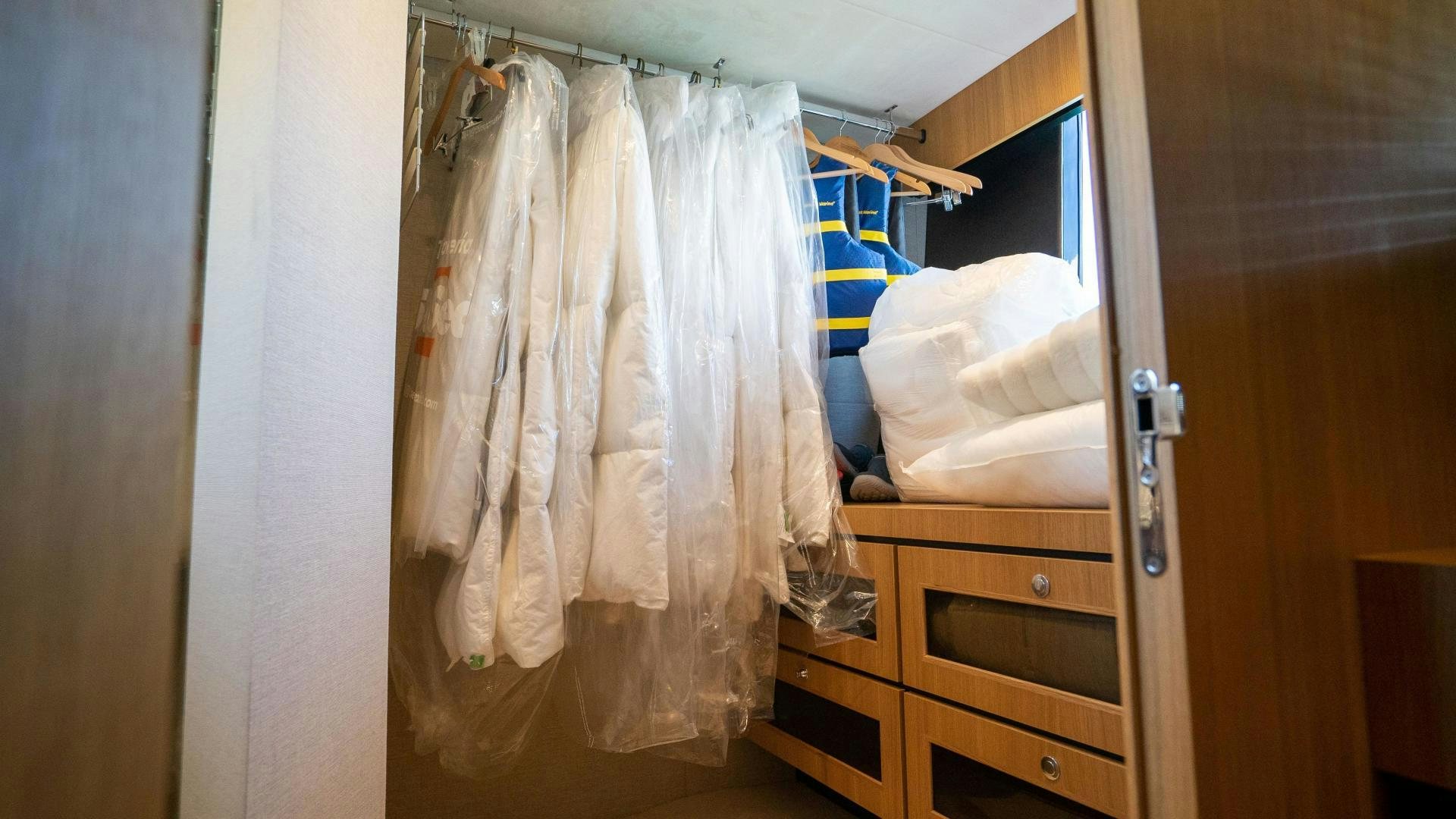a closet with clothes on the wall aboard OCHO UNO Yacht for Sale