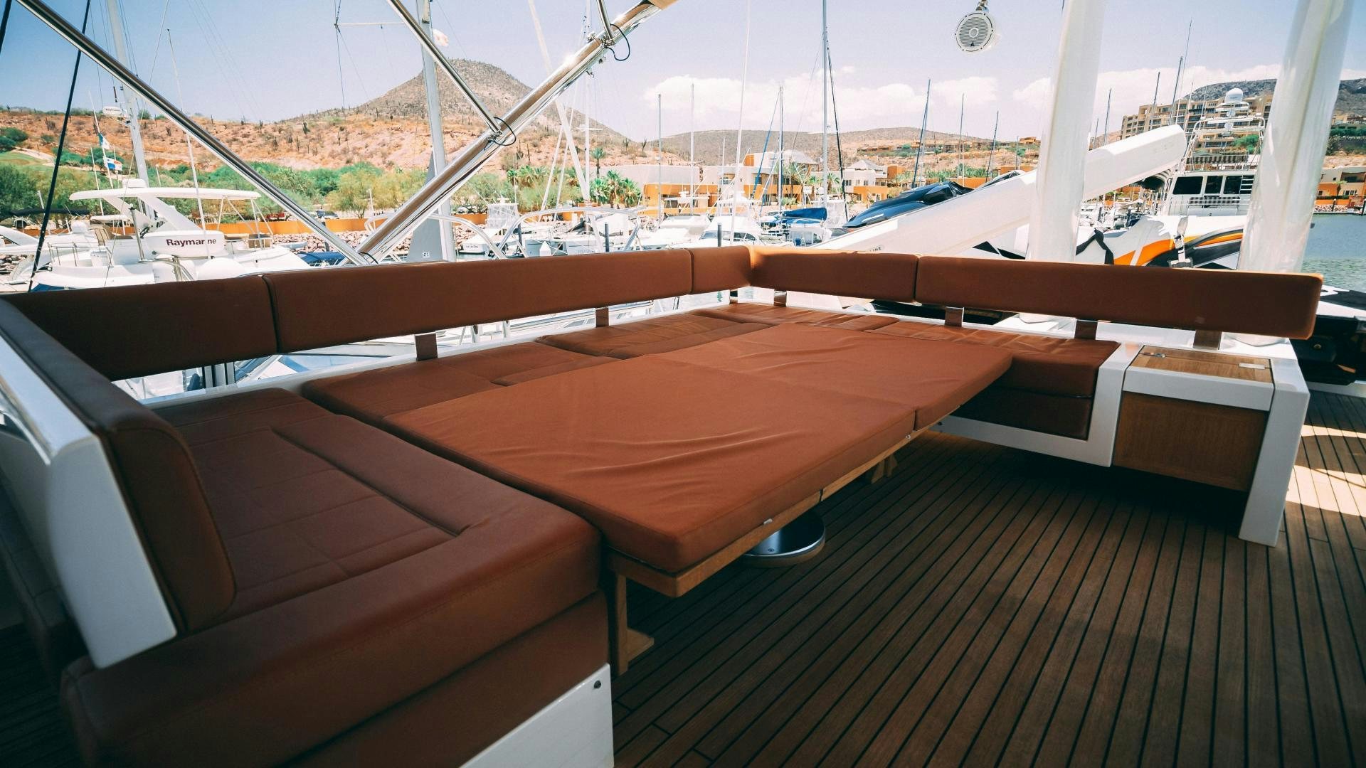 a wooden table on a deck overlooking a marina aboard OCHO UNO Yacht for Sale