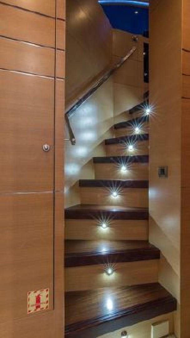 a wooden staircase with a glass door aboard NO LIMITS Yacht for Sale