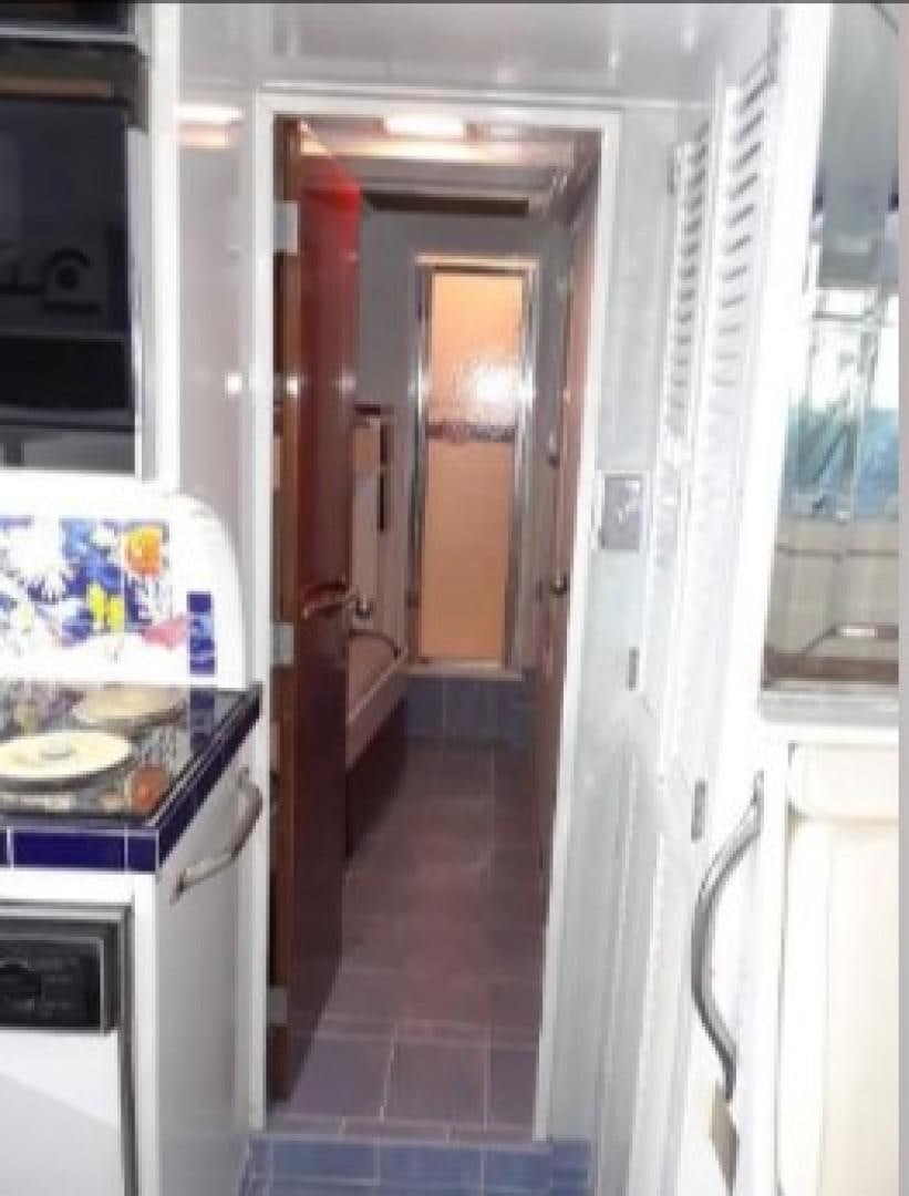 a kitchen with a fridge and a door aboard FANTASEA Yacht for Sale