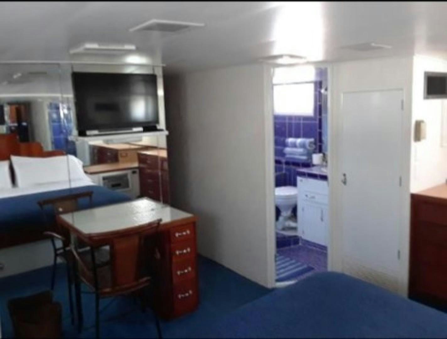 a room with a desk and a television aboard FANTASEA Yacht for Sale