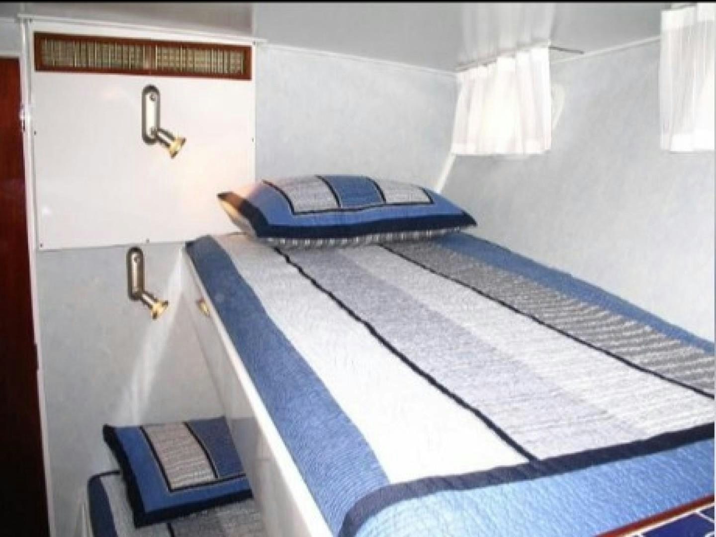 a bed with a blue blanket aboard FANTASEA Yacht for Sale