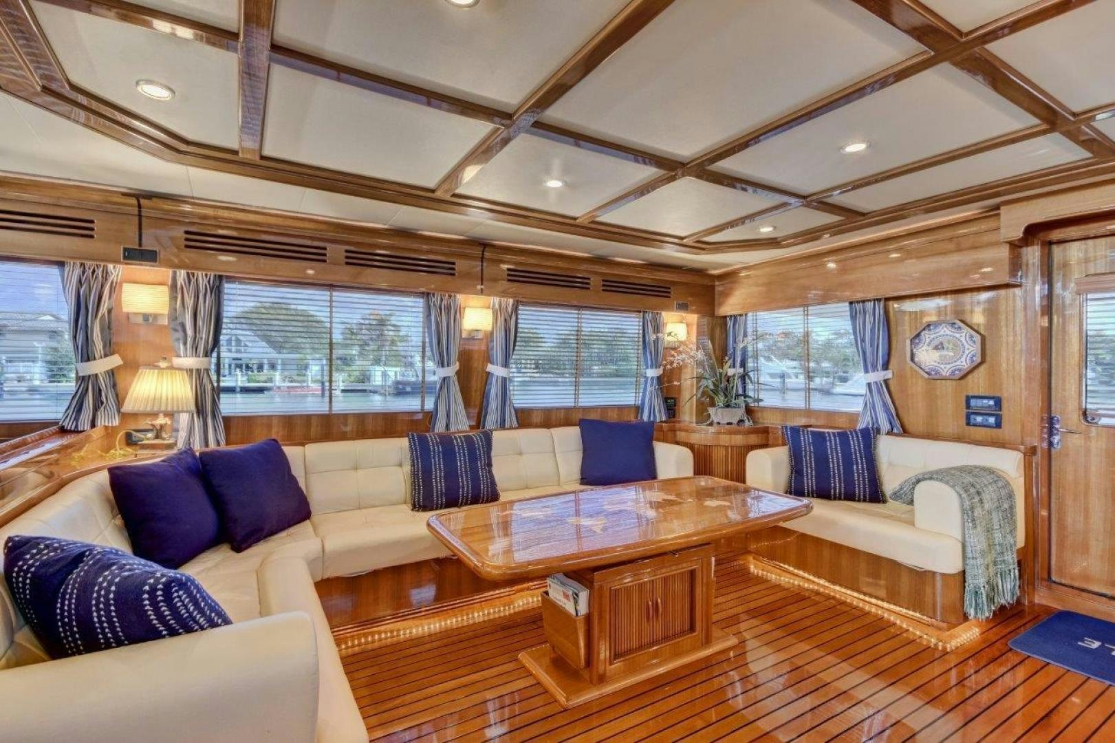 a living room with a table and couches aboard INEVITABLE Yacht for Sale