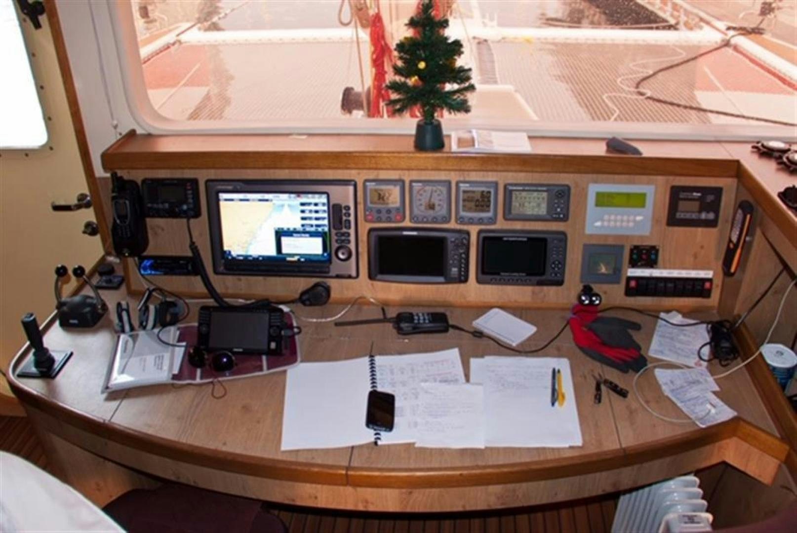 a desk with a computer and other electronics on it aboard HELICAT RED Yacht for Sale
