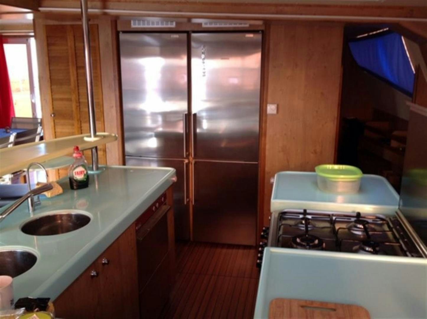 a kitchen with a fridge and sink aboard HELICAT RED Yacht for Sale