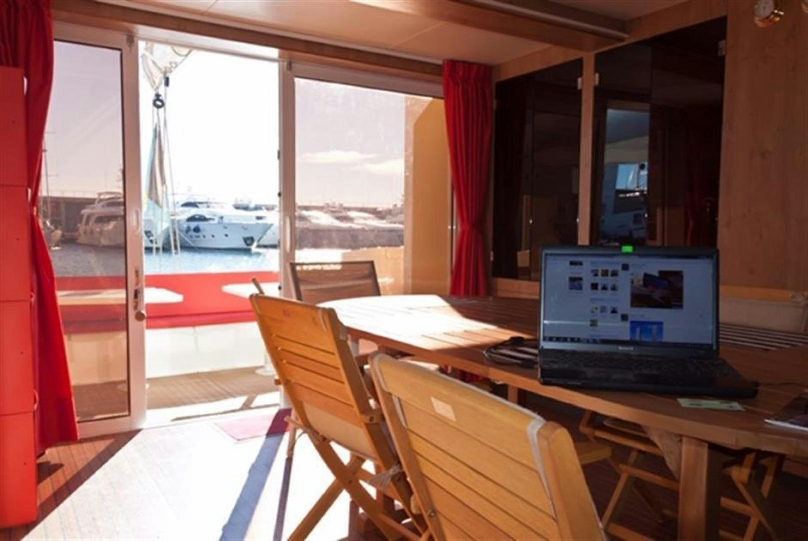 a laptop on a table aboard HELICAT RED Yacht for Sale