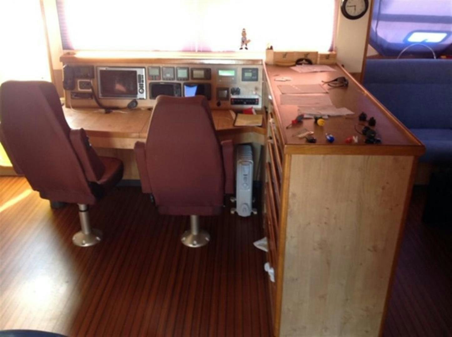 a room with a desk and chairs aboard HELICAT RED Yacht for Sale